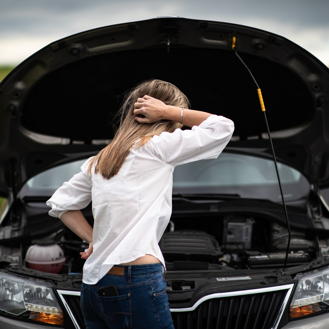 Driver standing beside a car with an open bonnet